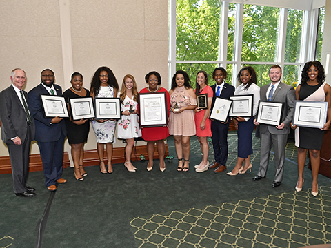 Group of professionals holding plaques.
