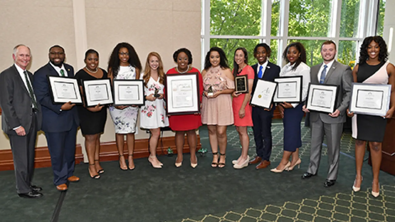 Group of professionals holding plaques.