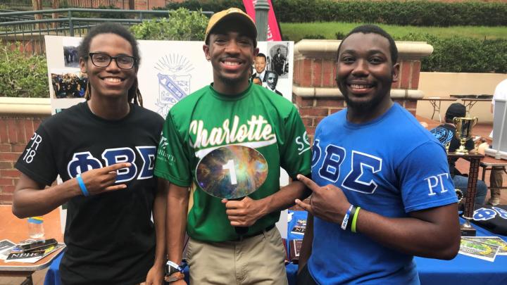 3 men representing a student organization at the Student Orgs Showcase