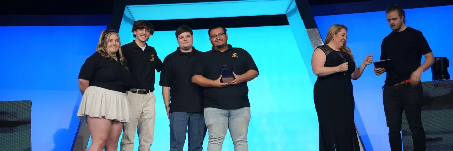 Niner Esports officers on stage winning the Club Program of the Year trophy.