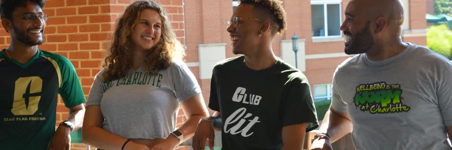 UNC Charlotte students smiling and looking at each other outside
