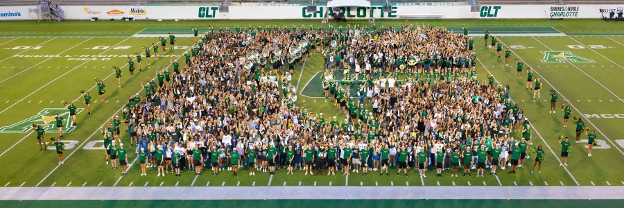 Approximately 1700 new students on football field in the shape of an All-in-C at the beginning of fall 2025