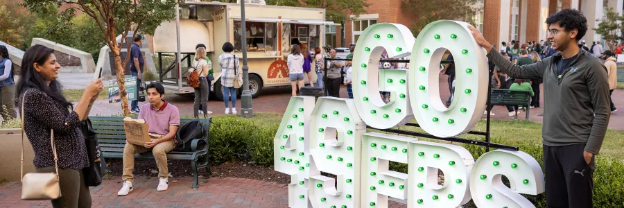Students outside taking pictures in front of oversized Go Niners sign at Niner Nation Week 2023