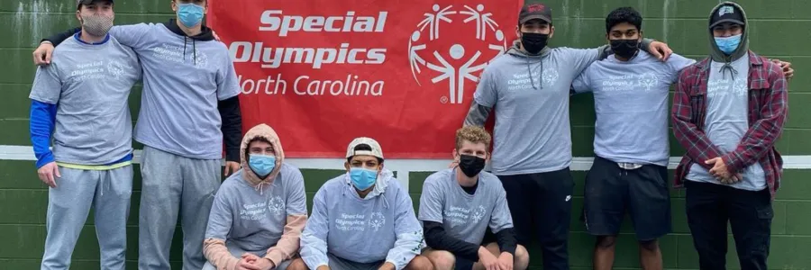 Members of the Sigma Tau Gamma fraternity standing in front of a banner for the North Carolina Special Olympics.