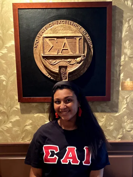 Falena Salcedo in front of her sorority's crest