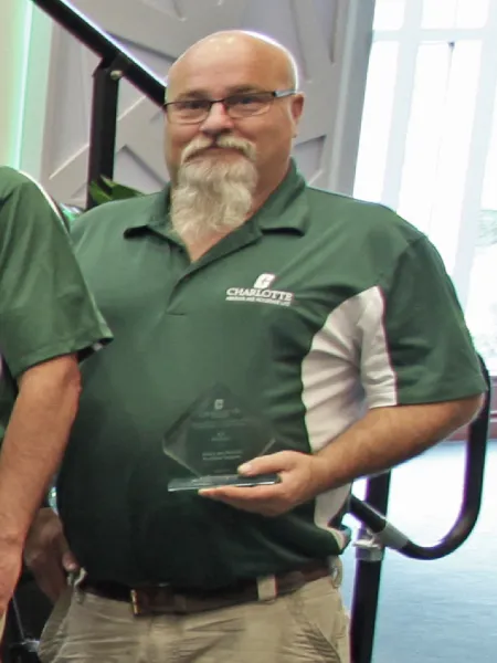 Bill Ballinger holding his Above and Beyond Award