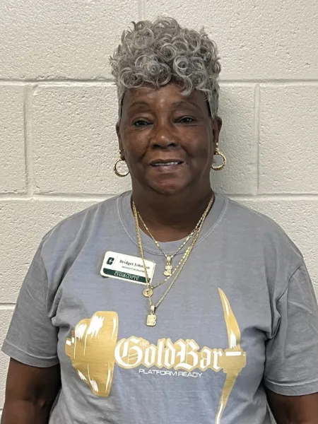 Bridget Johnson smiling in a UREC Gold Bar shirt