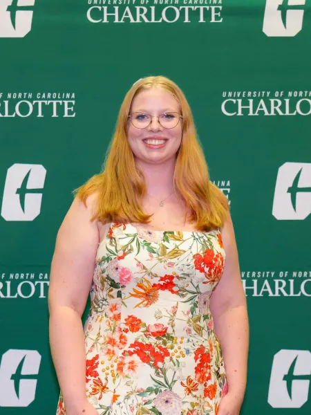 Emily Pierce smiling in front of a UNC Charlotte backdrop
