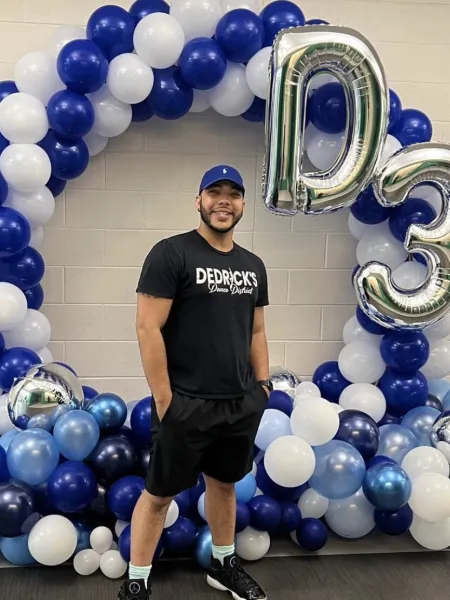 Dedrick-Perkins Barrier smiling next to balloons with his D3 branding