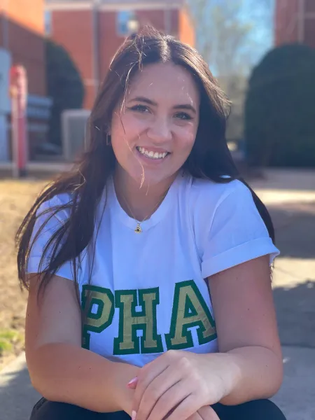 Emma Boger smiling while wearing a shirt for the Panhellenic Association.