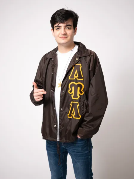 Danyal Mahmud smiling with a jacket showing his fraternity, Lambda Upsilon Lambda.