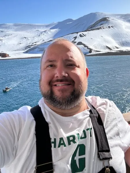 Jordan Słomiany smiling in a UNC Charlotte shirt while in Antarctica
