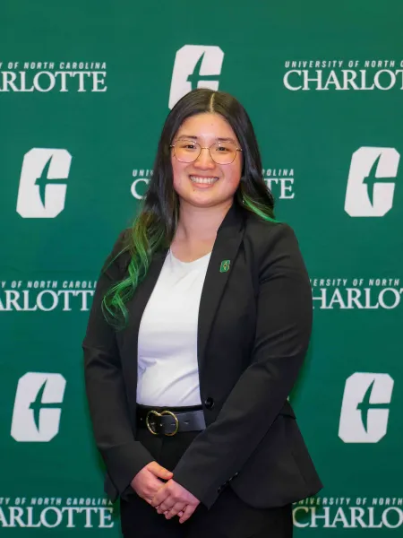 Lexue Zhao smiling in front of the UNC Charlotte backdrop