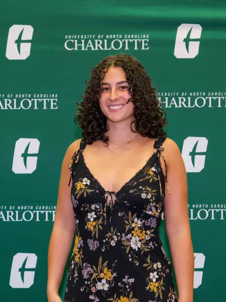 Macy Klein smiling in front of a UNC Charlotte backdrop