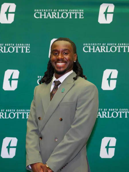 Patrick Bonna smiling with a UNC Charlotte backdrop