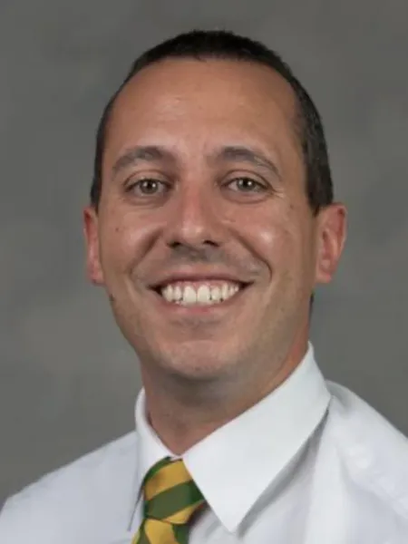 Larry Mellinger smiling with a green and yellow tie