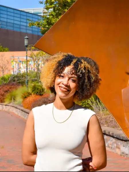 Shayauna Newsom smiling in a white top outside