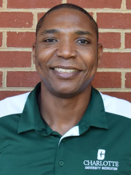 Chris Washington smiling in front of a brick wall