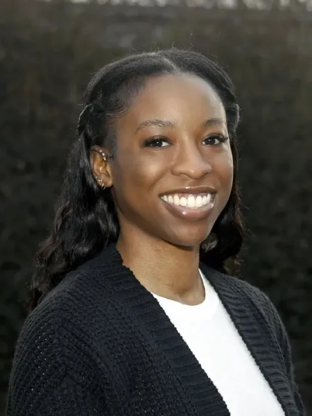 Alexis Rice smiling in a black sweater with a white shirt