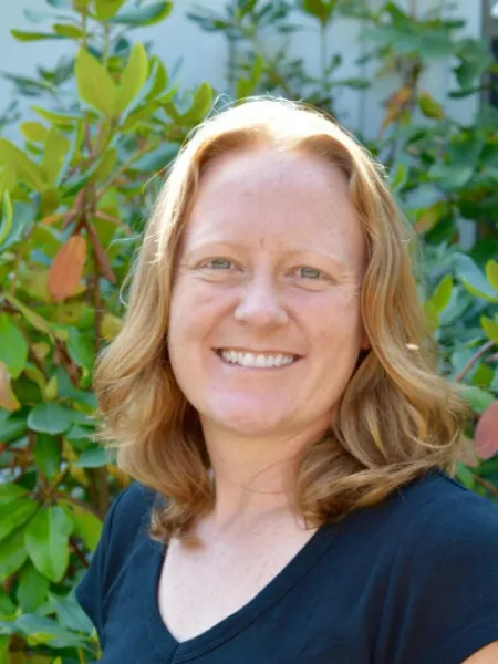 Kristin Coffey smiling in front of greenery