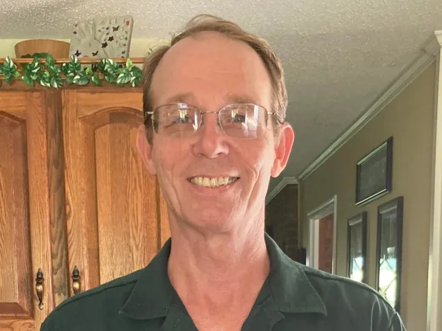 Randy Barnhill smiling while holding his Above and Beyond Award