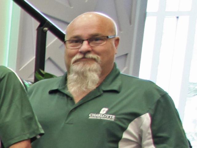 Bill Ballinger holding his Above and Beyond Award