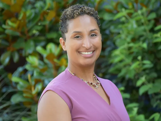 Denise Balfour Simpson smiling in front of greenery