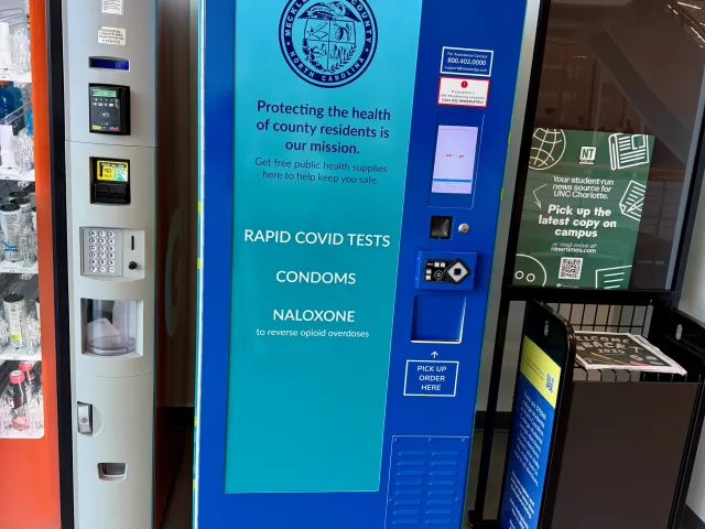 The public health kiosk in the third floor of UREC, it is blue with a lighter blue section that displays what is in the machine