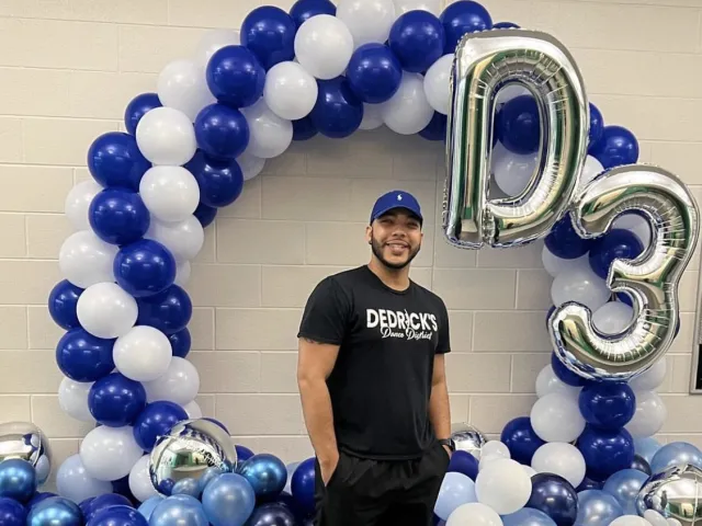 Dedrick-Perkins Barrier smiling next to balloons with his D3 branding