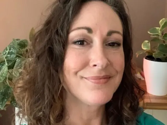 Lucian Wilhelm smiling with potted plants behind her