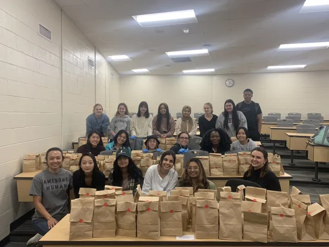 Members of AMWA with bags of menstrual products to hand out to students.