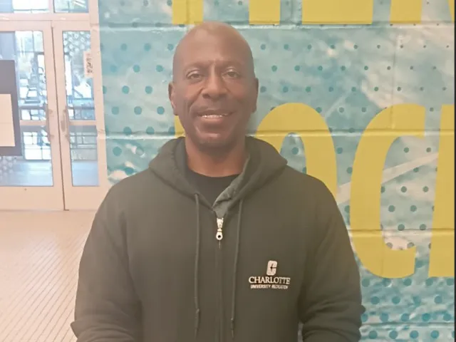 Sean Grandison smiling in UREC with a hoodie and gloves on