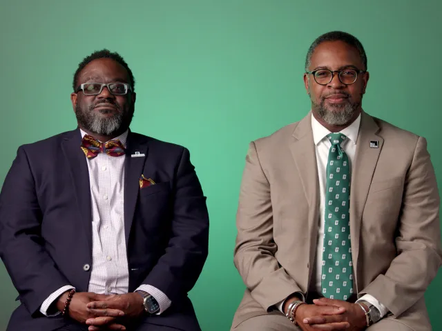 Larry Gourdine and Chris Smith sitting in front of a green background