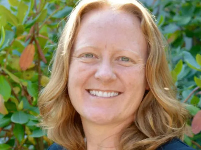 Kristin Coffey smiling in front of greenery