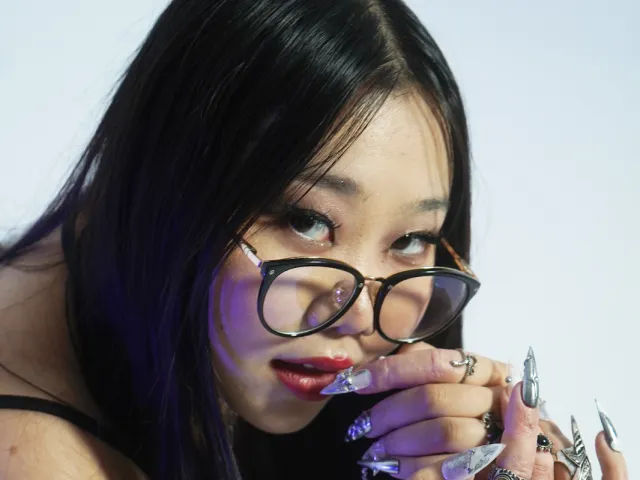 Sophia Park looking from the side with her creative nail designs on display on her hand