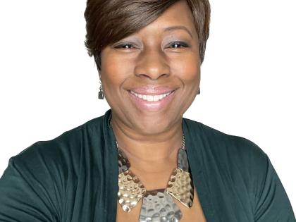 Shelia Higgs Burkhalter smiling with a blank background