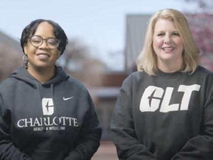 Dr. Mari Ross and Christine Reed Davis smiling with grey UNC Charlotte hoodies on