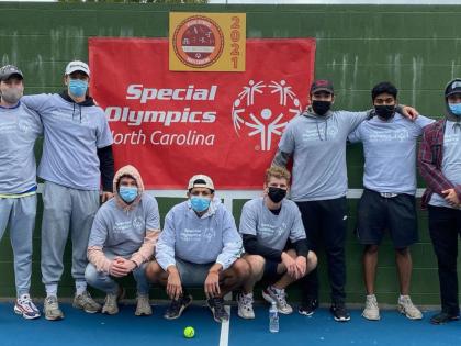 Members of the Sigma Tau Gamma fraternity standing in front of a banner for the North Carolina Special Olympics.