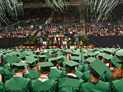 UNC Charlotte students in cap and gown at commencement