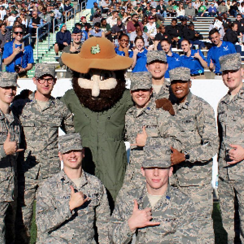Group of uniformed ROTC students standing with Norm the Niner.