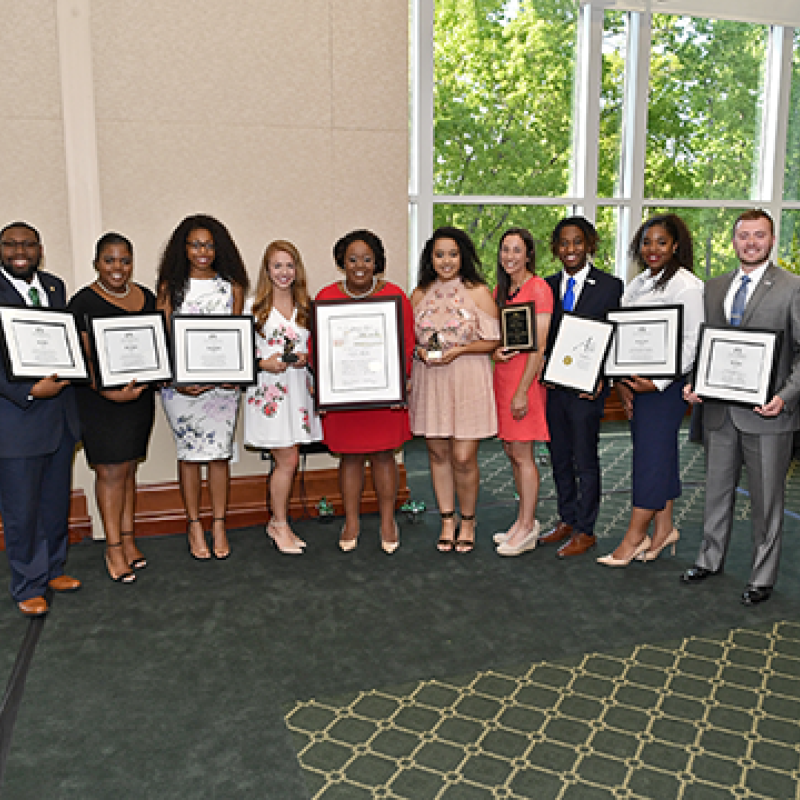 Group of professionals holding plaques.