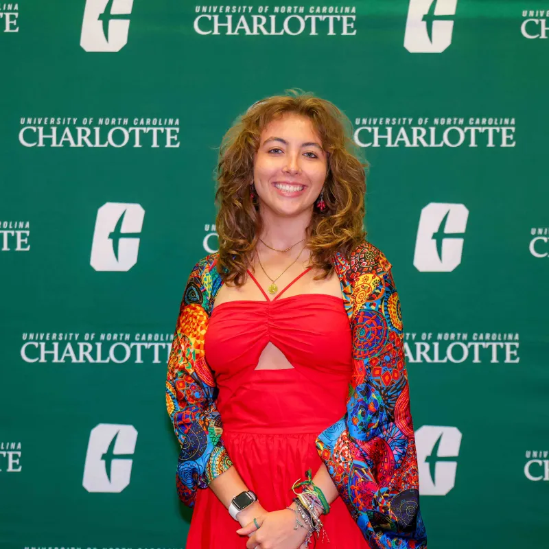 Maria Eduarda Cramer Filgueiras de Resende Silva smiling in front of a UNC Charlotte backdrop