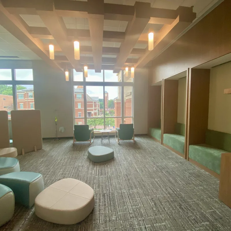 The Niner Nest furniture, warm lighting and view of the Cauble Quad