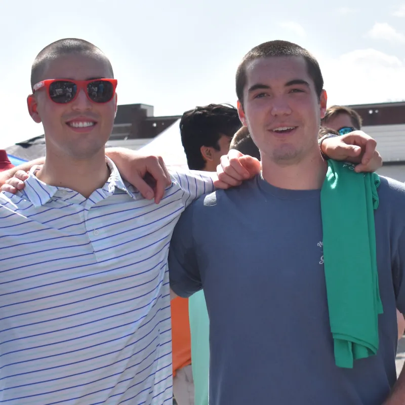 Four fraternity members with shaved heads to promote cancer research.