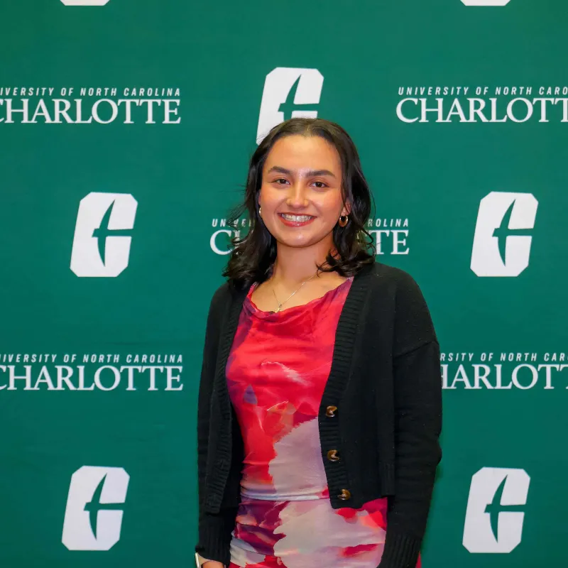 Yesenia Garcia smiling in front of a UNC Charlotte backdrop